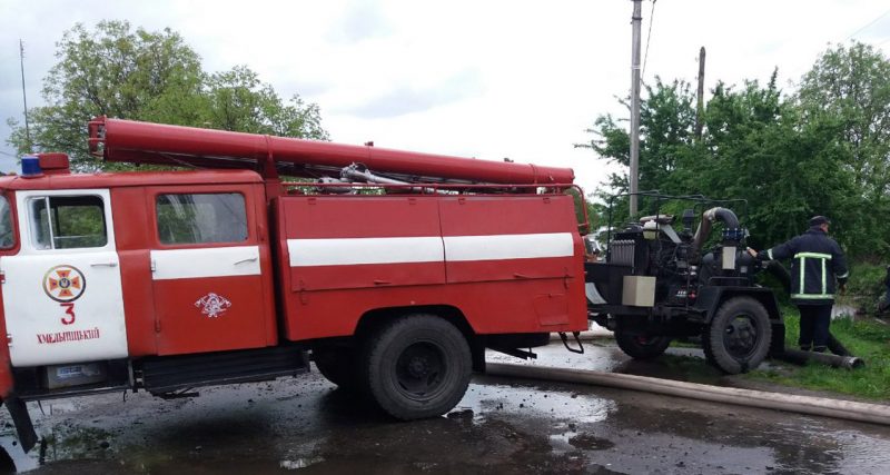 Пожежна машина відкачує воду із затопленного подвір'я